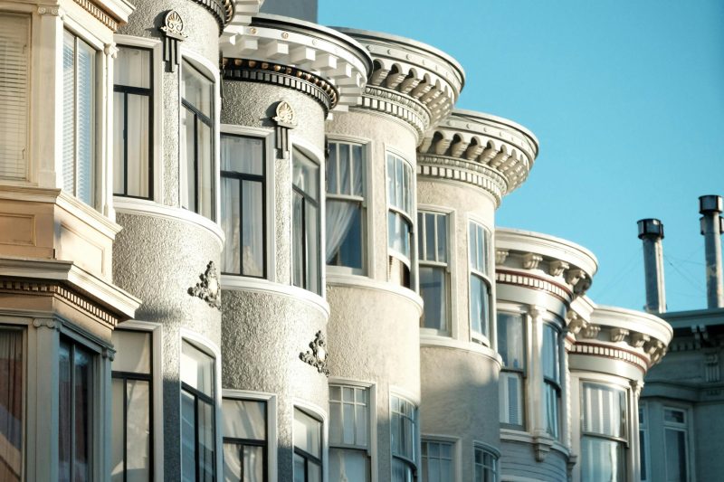 Elegant Victorian homes in San Francisco bathed in sunlight, showcasing intricate architectural details and a vibrant neighborhood.
