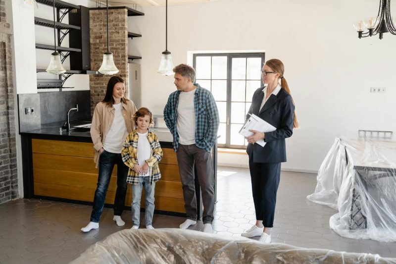 Family interacting with a real estate agent inside a bright, welcoming home interior.