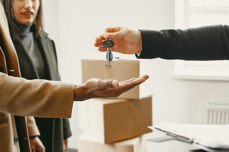 New homeowner joyfully holds keys in their new house, symbolizing a fresh start.