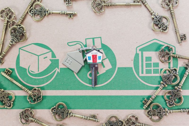 Vintage keys arranged with a modern house key, symbolizing real estate investment.