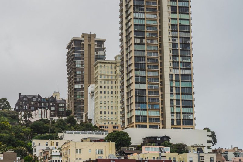 Modern residential towers rise against the San Francisco skyline, showcasing contemporary architecture amid a vibrant cityscape.