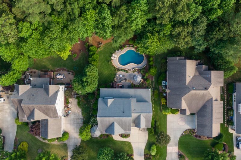 Aerial view of a Wake Forest, NC suburb with green backyards and a swimming pool.