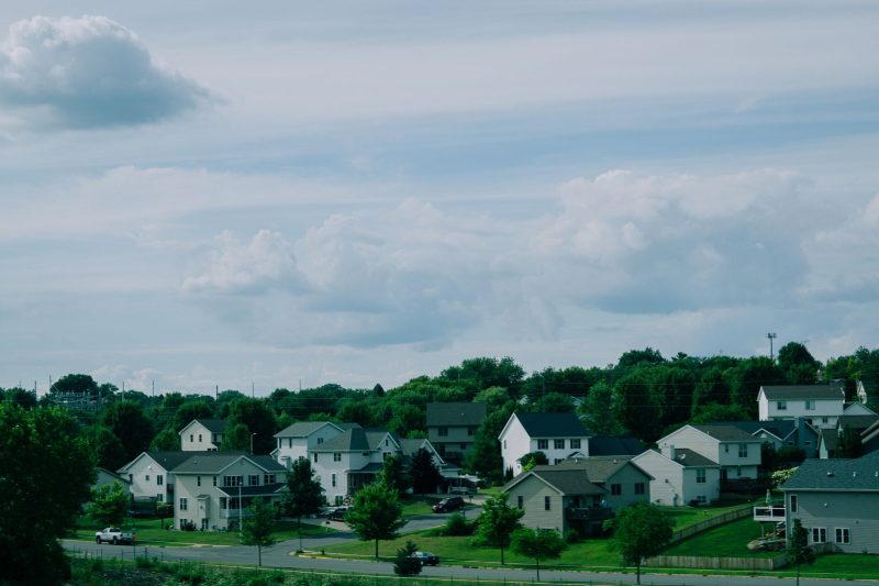 Picturesque suburban houses under a blue sky with fluffy clouds in a Wisconsin neighborhood.