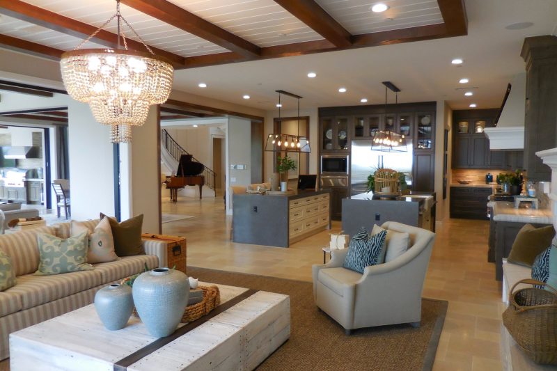 Spacious living room with elegant decor, an open kitchen area, chandelier, and comfortable furnishings.